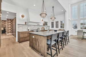 Kitchen with decorative light fixtures, plenty of natural light, and light hardwood / wood-style flooring