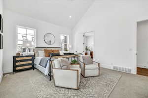 Bedroom featuring light colored carpet and high vaulted ceiling