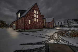 View of snowy exterior featuring a garage