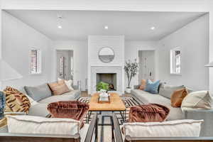 Living room featuring a wealth of natural light, a fireplace, and wood-type flooring