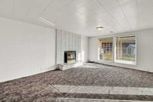 Unfurnished living room featuring carpet and a fireplace