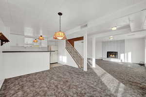 Unfurnished living room featuring light carpet and a fireplace