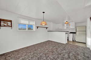 Unfurnished living room featuring light carpet