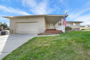 View of front of house featuring a front lawn and a garage