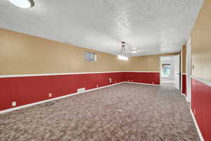 Carpeted empty room featuring a textured ceiling