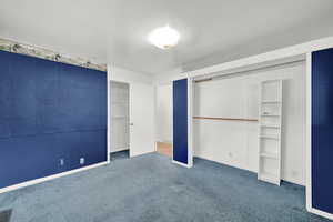 Unfurnished bedroom with dark colored carpet and a closet