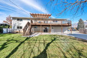 Rear view of house with a deck with mountain view and a yard