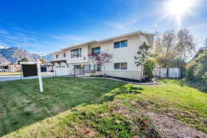 Raised ranch featuring a mountain view, a garage, and a front lawn