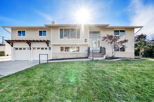 Bi-level home with a front yard and a garage