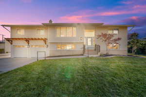 View of front facade with a lawn and a garage