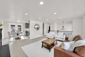 Living room featuring a notable chandelier, a textured ceiling, and light hardwood / wood-style flooring