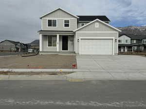 View of front of home with a mountain view and a garage