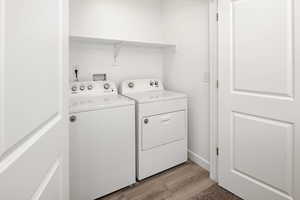 Clothes washing area featuring light wood-type flooring and separate washer and dryer