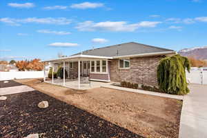 Rear view of property featuring a mountain view a covered patio and RV pad