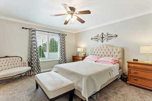 Bedroom with carpet flooring, ceiling fan, and crown molding