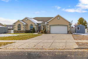 Ranch-style home featuring a front yard, a shed, and a garage