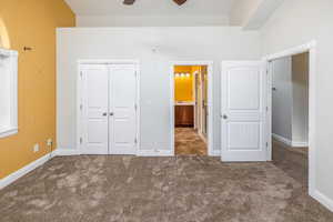 Unfurnished bedroom featuring ceiling fan, a closet, and carpet