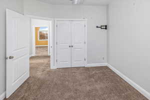 Unfurnished bedroom featuring carpet and a closet