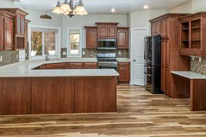 Kitchen featuring kitchen peninsula, sink, light hardwood / wood-style flooring, and appliances with stainless steel finishes