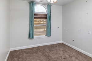 Carpeted spare room with ceiling fan