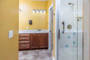 Bathroom featuring a shower with door and vanity