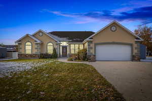 Ranch-style home featuring a garage and a yard