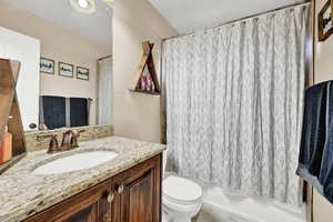 Full bathroom with vanity, toilet, and shower / tub combo with curtain