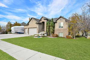 View of front of property featuring a front lawn and a garage