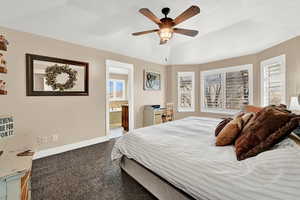 Bedroom featuring connected bathroom, ceiling fan, and light carpet