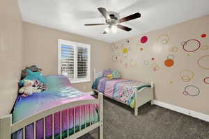 Carpeted bedroom featuring ceiling fan