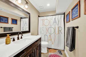 Bathroom featuring tile patterned flooring, vanity, and toilet