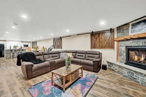 Living room featuring light hardwood / wood-style floors and a stone fireplace