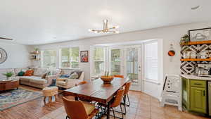 Tiled dining room with a chandelier