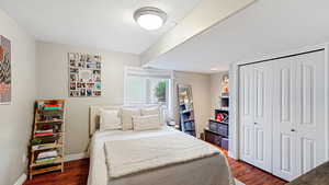 Bedroom featuring dark hardwood / wood-style flooring and a closet