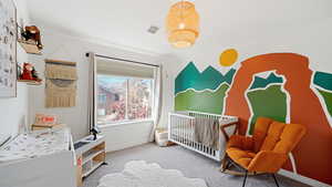 Bedroom featuring carpet floors and a nursery area