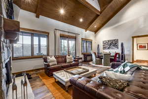 Living room with beam ceiling, wood-type flooring, wood ceiling, and high vaulted ceiling