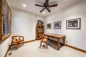 Carpeted home office with ceiling fan