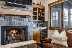 Bar with a stone fireplace and beverage cooler