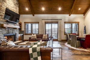 Living room with beam ceiling, wood-type flooring, a fireplace, and wood ceiling