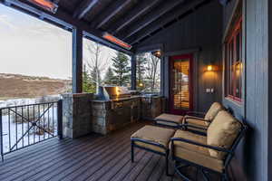 Deck with an outdoor kitchen and a grill