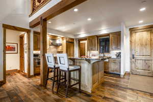 Kitchen with decorative backsplash, dark hardwood / wood-style floors, oven, and wall chimney range hood