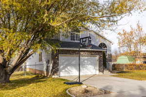 View of front of house featuring a front lawn and a garage