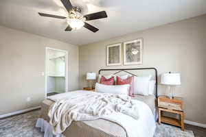 Carpeted bedroom featuring ceiling fan, a walk in closet, and a closet