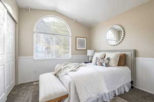 Carpeted bedroom with lofted ceiling