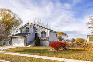 View of front of house featuring a front yard and a garage