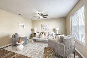 Living room featuring hardwood / wood-style floors, a textured ceiling, and ceiling fan