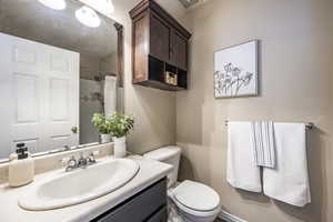 Bathroom with a shower with shower curtain, vanity, and toilet