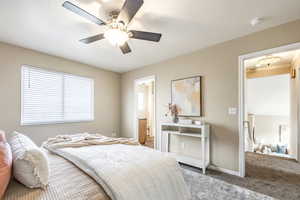 Bedroom with carpet flooring, ceiling fan, and ensuite bath