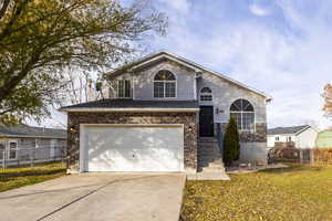 View of property featuring a front yard and a garage