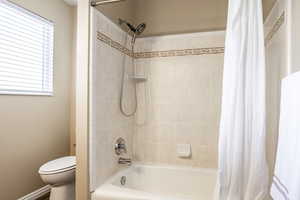 Bathroom featuring shower / tub combo and toilet